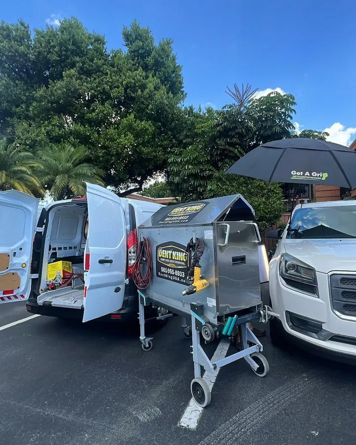 Dent King paintless dent repair setup with branded equipment cart and service van in South Florida