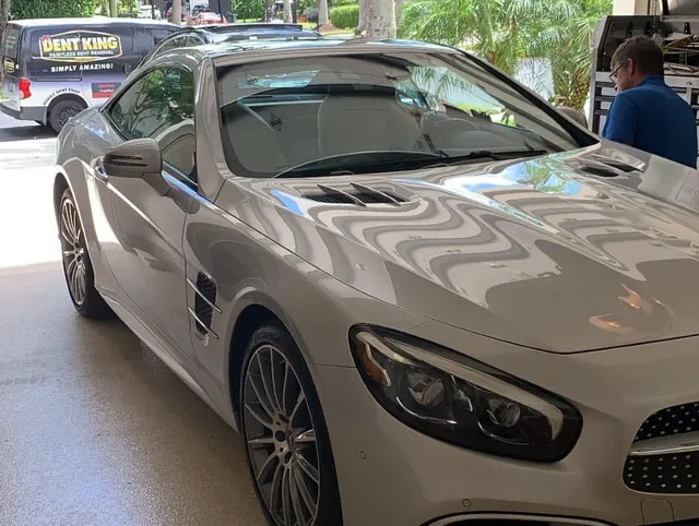 Silver Mercedes-Benz SL convertible in a professional Dent King service bay